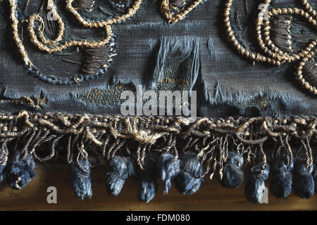 L'antichambre de la Reine à Ham House, Surrey. Fermer détail de la bordure inférieure de la paroi nord-pendaison avant le traitement de restauration. La frontière est de velours de soie bleu brodé de fils dorés à l'argent. Le fringe une tresse d'argent doré à la tête d'un Banque D'Images