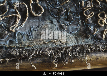 L'antichambre de la Reine à Ham House, Surrey. Fermer détail de la bordure inférieure de la paroi nord-pendaison avant le traitement de restauration. La frontière est de velours de soie bleu brodé de fils dorés à l'argent. Le détail montre une usure importante de la vel de soie Banque D'Images