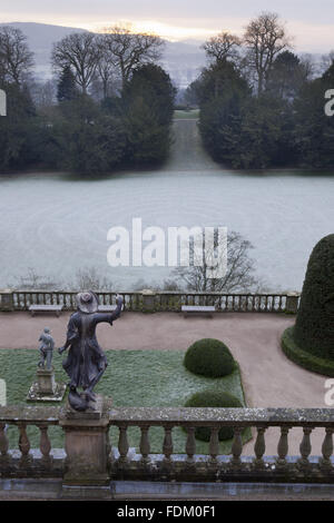 Vue sur la terrasse et l'Orangerie volière exposée et le labyrinthe d'herbe en hiver dans le jardin du château de Powis, Welshpool, Powys. Banque D'Images