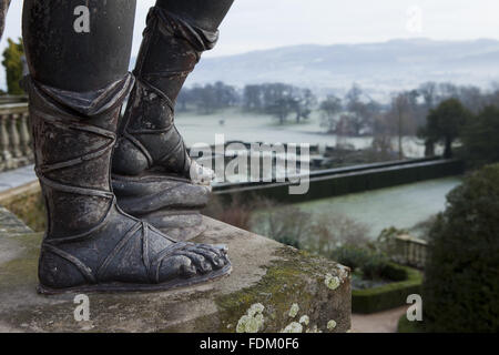 Les pieds d'une statue de plomb d'un berger sur la terrasse de la Volière en hiver dans le jardin du château de Powis, Welshpool, Powys. Banque D'Images