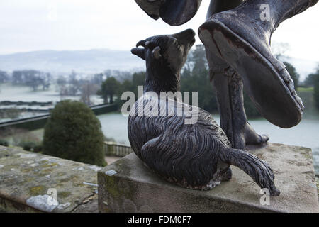 Les pieds d'une statue de plomb d'un berger et un mouton sur la terrasse de la Volière en hiver dans le jardin du château de Powis, Welshpool, Powys. Banque D'Images