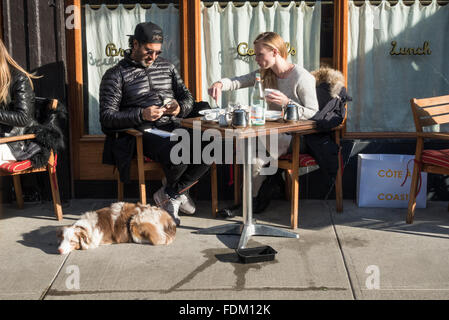 Couple ayant un déjeuner en plein air avec leur chien berger australien à l'extérieur restaurant de New York Banque D'Images