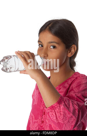 Jeune adolescente de boire de l'eau fraîche d'une bouteille sur fond blanc Banque D'Images