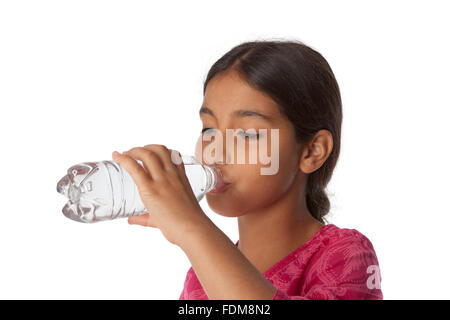 Jeune adolescente de boire de l'eau fraîche d'une bouteille sur fond blanc Banque D'Images