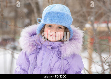 Portrait d'une petite fille de cinq ans heureux dans la neige de l'hiver Banque D'Images