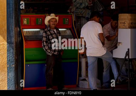 Un homme regarde à partir d'un jeux boutique dans Jalpan, au Mexique. Banque D'Images