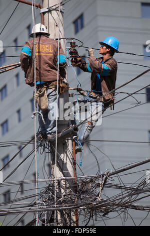 La ville de Cebu, Philippines,Société d'électricité employés travaillant sur des lignes électriques aériennes. Banque D'Images