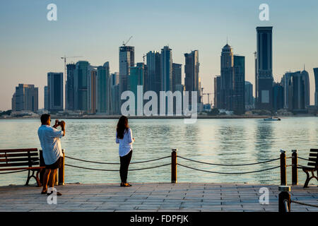 Les touristes de prendre des photos avec les gratte-ciel de West Bay, dans le contexte, Doha, Qatar Banque D'Images