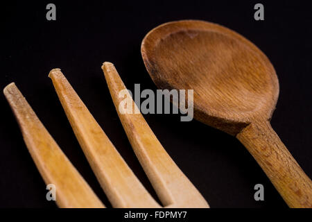 Still Life de couverts en bois sculpté isolated on black Banque D'Images