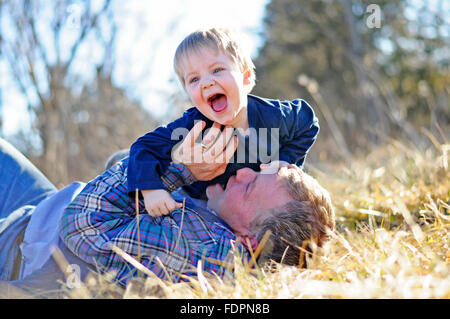 Père chatouillant ventre d'Enfant heureux Banque D'Images