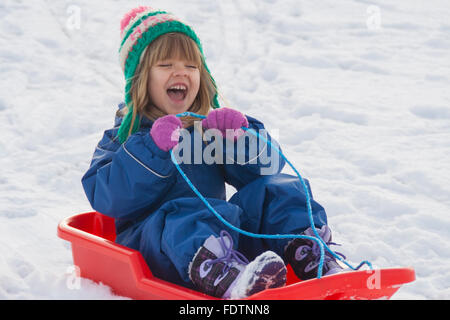 Petite fille de la luge en bas de la colline dans le Tagagstan Play Park, Kirriemuir, Ecosse, 2016 Banque D'Images