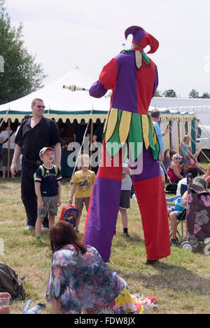 TEWKESBURY, des bureaux extérieurs. UK-11 JUILLET : Jester sur pilotis balades parmi foule juggling le 12 juillet 2014 à Tewkesbury Fête médiévale Banque D'Images