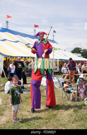 TEWKESBURY, des bureaux extérieurs. UK-11 JUILLET : Jester sur pilotis balades parmi foule juggling le 12 juillet 2014 à Tewkesbury Fête médiévale Banque D'Images