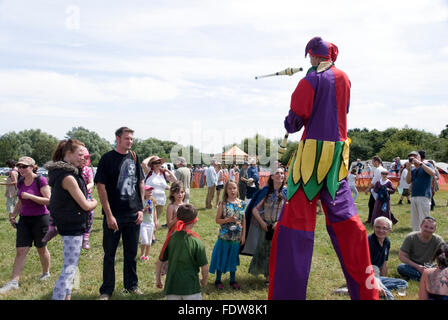 TEWKESBURY, des bureaux extérieurs. UK-11 JUILLET : Jester sur pilotis balades parmi foule juggling le 12 juillet 2014 à Tewkesbury Fête médiévale Banque D'Images