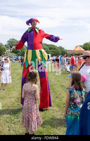 TEWKESBURY, des bureaux extérieurs. UK-11 JUILLET : Jester sur pilotis balades parmi foule juggling le 12 juillet 2014 à Tewkesbury Fête médiévale Banque D'Images