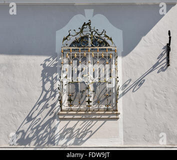 En plein air avec grille fenêtre antique de longues ombres sur le mur de Mondsee, Autriche Banque D'Images