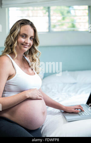 Femme enceinte à l'aide d'un ordinateur portable Banque D'Images