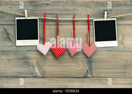 Coeurs rouges et blancs vintage cadre photo Polaroid suspendu à la corde à linge. Décoration Saint Valentin fait main Banque D'Images