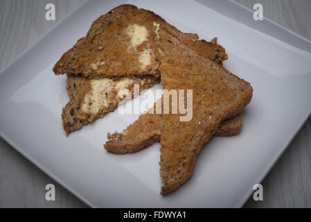 Toasts avec du beurre sur une plaque Banque D'Images