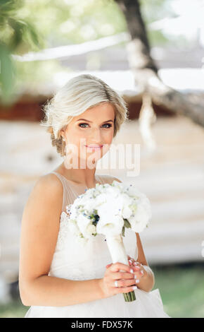 Mariée avec un bouquet qui pose à l'appareil photo Banque D'Images