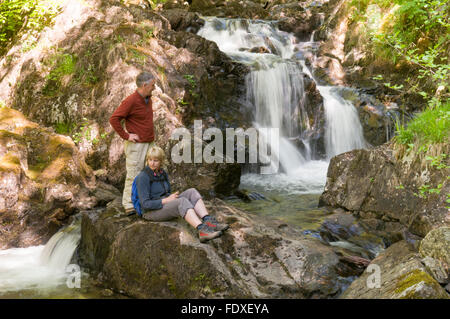 Les marcheurs à côté de cascades sur Rydal Beck, au-dessus de l'eau, Rydal, Cumbria (Royaume-Uni). Mai. Banque D'Images