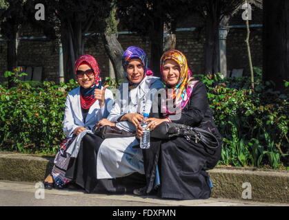 Trois filles assis avec headscarfs colorés en Turquie. Banque D'Images