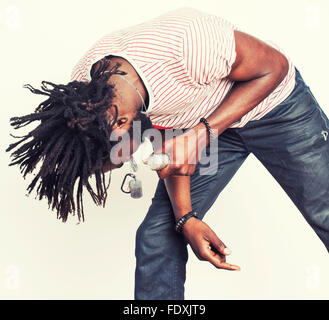 Handsome young african american boy chantant avec microphone émotionnelle isolé sur fond blanc, en mouvement gesturing smiling Banque D'Images