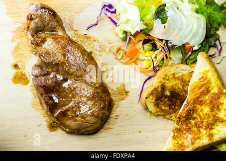 Les steaks grillés sur bois avec salades et de pain Banque D'Images