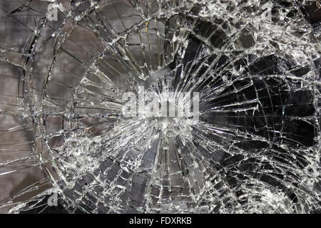 Verre brisé et fissuré avec un trou dans le centre Banque D'Images