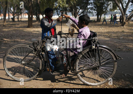 Dhaka, Bangladesh. Feb, 2016 2. DHAKA, BANGLADESH - 02 février : Mohammad Shahjahan 30 typhoïde un boiteux sellign nourriture dans un parc à Dhaka, Bangladesh, 02 février 2016.Shahjahan a subi la typhoïde lorsqu'il était âgé de 2 ans et perd ses jambes. Maintenant il survivre en vendant des aliments sur park et street.La fièvre typhoïde est une cause majeure de la maladie dans la plupart des pays en développement, y compris le Bangladesh. Une estimation récente révèle que 22 millions de nouveaux cas de typhoïde surviennent chaque année dans le monde, avec environ 200 000 de ces entraînant la mort. Le Bangladesh est situé dans une région où la fièvre typhoïde est fortement endemi Banque D'Images