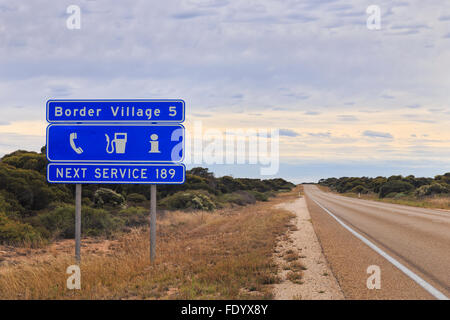 Information bleu panneau routier dans l'ouest de l'Australie au sujet de prochain entretien ainsi que point de vue de l'autoroute en direction de Villa Frontière Eyre Banque D'Images