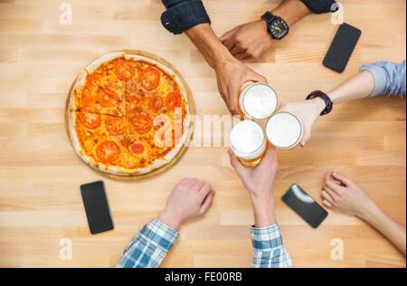 Vue de dessus du groupe multiethnique des jeunes boire de la bière et manger des pizzas Banque D'Images