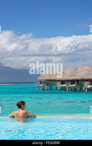 Femme dans la piscine à l'hôtel Sofitel, Moorea, îles de la société, Polynésie Française Banque D'Images