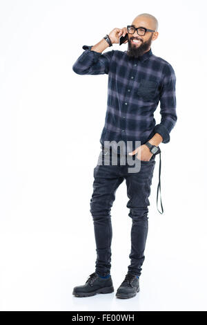 Full Length portrait of smiling african american barbu debout et talking on mobile phone Banque D'Images