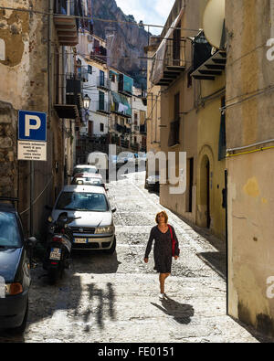 Femme marche dans la rue, ville de Cefalù et commune de la Province de Palerme, Sicile, Italie Banque D'Images