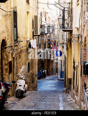 Vespa scooter stationné sur la rue ruelle dans Cefalu ville italienne de la Province de Palerme, Sicile, Italie Banque D'Images