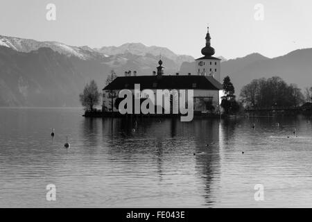 Une image en noir et blanc de Schloss ort à Gmunden, en Autriche, avec des montagnes enneigées en arrière-plan Banque D'Images