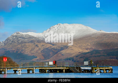 Le Loch Lomond, au Royaume-Uni. 3 Février, 2016. Après les récentes tempêtes et fortes pluies pour la saison, le niveau d'eau à Luss sur le Loch Lomond a surmonté les murs provoquant des inondations locales.Sur la première journée ensoleillée, Tom Wilson et la Géorgie à partir de Londres, en vacances près de Luss, prendre une promenade relaxante pour admirer la neige surmonté Ben Lomond et les eaux calmes du Loch Lomond. Credit : Findlay/Alamy Live News Banque D'Images