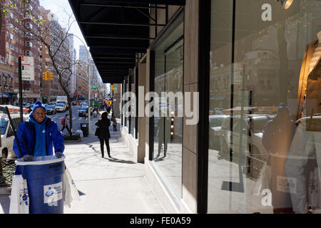 Un homme employé par le doe Fund avec l'équipement de nettoyage de rue sur Madison Avenue. L'entité opérationnelle désignée Fonds aide anciens sans-abri. Banque D'Images