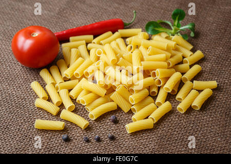 Rigatoni pâtes crues sur fond de jute Banque D'Images