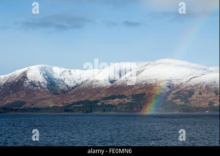 Vue d'un arc-en-ciel et montagnes couvertes de neige sur le Loch Linnhe, près de Fort William en Ecosse UK Banque D'Images