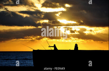 Brighton, UK. 3 Février, 2016. Météo France : un pêcheur jette dehors à la mer au coucher du soleil sur le front de mer de Brighton ce soir après une journée froide mais ensoleillée sur la côte sud Crédit : Simon Dack/Alamy Live News Banque D'Images