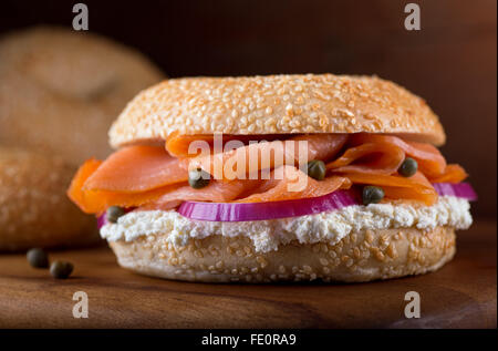 Un délicieux petit bagel au sésame avec saumon fumé, crème fouettée, de fromage, d'oignons rouges et câpres. Banque D'Images