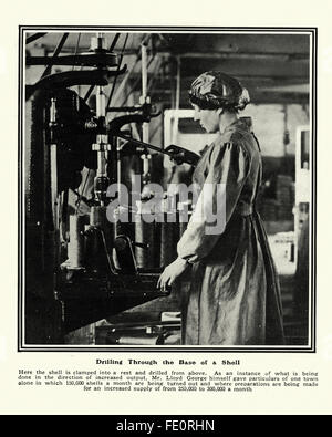 Femme travaillant dans une usine de munitions de la première guerre mondiale à travers la base de forage d'une coquille d'artillerie Banque D'Images