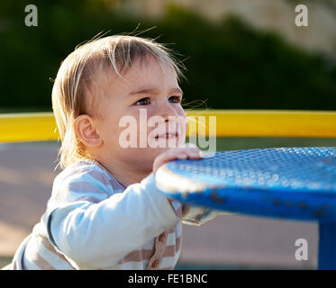 Mignon bébé garçon enfant jouant dans l'aire de jeu. Tout-petit à l'aire de playpot. Banque D'Images