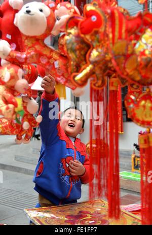 Yuqing. Feb, 2016 4. Un garçon choisit décoration lors d'un marché de pays dans Yuging County, au sud-ouest de la province du Guizhou, en Chine, le 4 février 2016 pour saluer le printemps prochain Festival qui tombe le 8 février. Credit : Long Yuanbin/Xinhua/Alamy Live News Banque D'Images