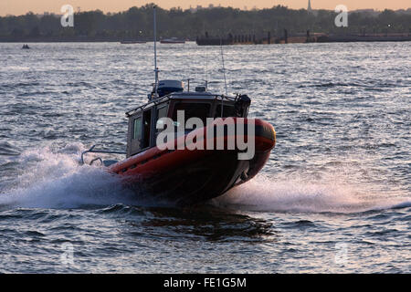 25' Classe Defender US Coast Guard RB-S Le bateau de patrouille saute par une vague sur la rivière Hudson à New York City at Dusk Banque D'Images