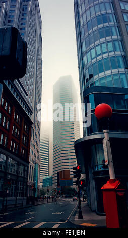 Matin brumeux dans une rue par des gratte-ciel Banque D'Images