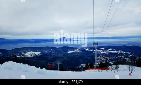 Câble rouge voiture à la montagne. Station de ski de Poiana Brasov, Carpates, Roumanie. Beau paysage d'hiver avec la neige covere Banque D'Images