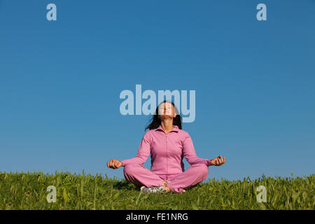 Woman doing yoga relaxant à l'extérieur Banque D'Images